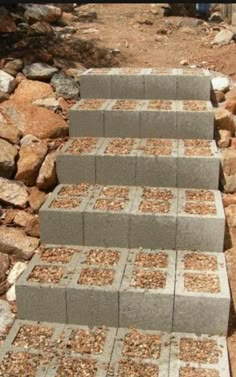 several cinder blocks stacked on top of each other in front of rocks and dirt area