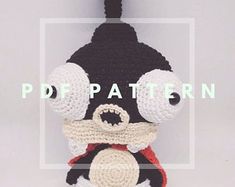 a crocheted black and white stuffed animal wearing a red scarf, with the words pdf pattern above it