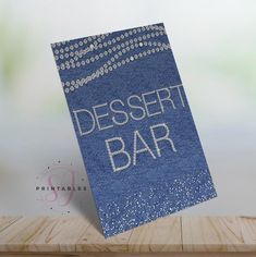 a blue dessert bar sign sitting on top of a wooden table