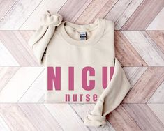 a sweater with the words peds nurse on it is laying on a wood floor