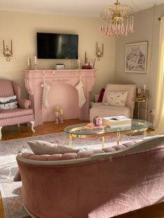 a living room filled with furniture and a flat screen tv mounted on the wall above a fireplace