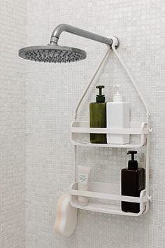 a shower head with soap, shampoo and lotion on it