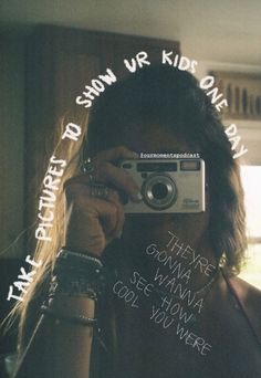 a woman taking a selfie in front of a mirror with words written on it