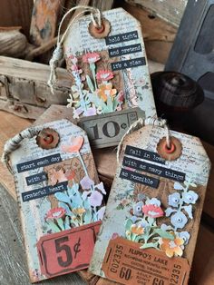 three tags with flowers and numbers on them