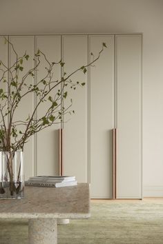 a vase filled with branches on top of a table