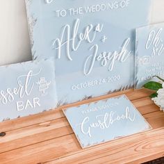 wedding signs are displayed on a wooden table