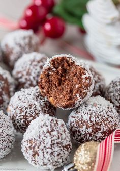 chocolate covered donuts with powdered sugar on top and christmas decorations in the background