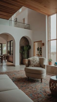 a living room filled with furniture and large windows