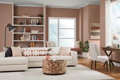 a living room with pink walls and white furniture