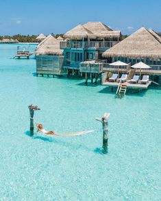 a hammock in the water next to some huts