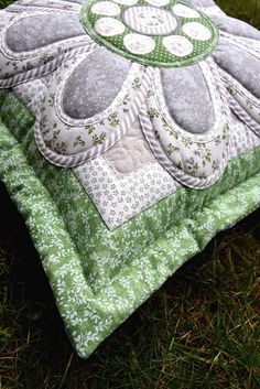 a green and white pillow sitting on top of grass