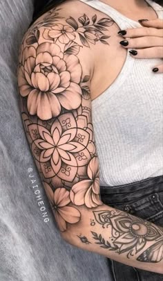 a woman's arm with flowers on it, and her hand resting on the shoulder