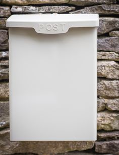 a white dishwasher sitting next to a stone wall with the word tso on it