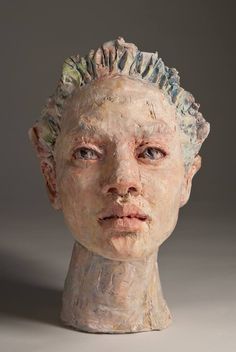 a clay head with hair on top of it