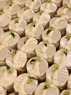 wedding favors are arranged on top of each other with green flowers in the center and ribbons around them