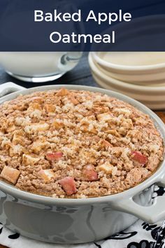 baked apple oatmeal in a white dish on top of a wooden table