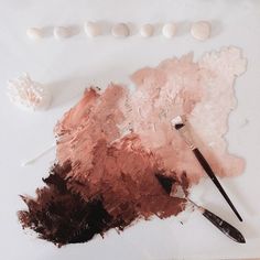 an artist's palette with paint, brushes and seashells