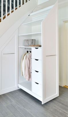 an open closet under the stairs in a house