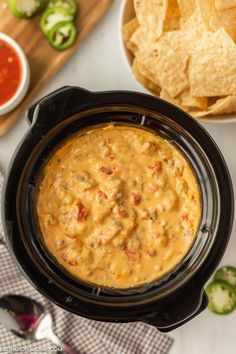 a crock pot filled with salsa and tortilla chips