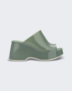 An outer side view of a light green Melissa Patty platform mule Modern Spring Platform Sandals, Modern Platform Sandals For Spring, Modern Chunky Platform Slip-on Mules, Modern Slides With Sculpted Heel, Spring Open Toe Platform Slippers With Sculpted Heel, Chic Platform Slide Slippers, Modern Platform Sandals With Round Toe, Modern Spring Sandals With Round Toe, Modern Platform Wedge Sandals For Spring