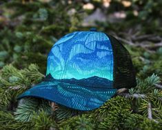 Have you seen them? Dazzling ribbons of light dance in the night sky on our Northern Lights Trucker Hat. Whether you've seen them in person or dream of glimpsing the aurora borealis, our hat is the perfect fit. The artwork was hand-carved and printed with traditional block printing tools and digitally colored. ITEM DETAILS Alpinecho's trucker hats are made in partnership with Purnaa, a social enterprise and World Fair Trade Organization Guaranteed Member (WFTO) in Nepal with a mission to create World Fair, Social Enterprise, Greeting Card Set, Neck Gaiters, Sticker Patches, The Night Sky, Block Printing, Neck Gaiter, Have You Seen