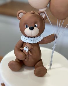 a cake with a teddy bear and balloons on it