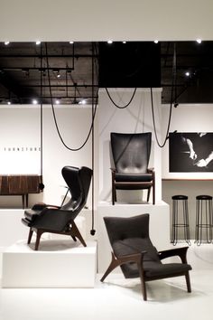 chairs and stools are on display in a room