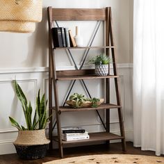 a wooden shelf with books and plants on it next to a potted snake plant