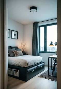 a bed room with a neatly made bed next to a window and a table in front of it