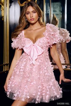 Ready for a fashion cavity? There is nothing sweeter for homecoming than Sherri Hill style 56585. This short baby doll dress has beautiful puff sleeves and and a sweetheart neckline accented with a beautiful bow. Flower like appliqus cover this beautiful a-line silhouette making it a standout piece in Sherri Hill's newest collection for fall 2024. If you are looking for a dress for date night, a homecoming dress, or an appearance ensemble when you when your next state title then shop Sherri Hill right here at Terry Costa Sherri Hill Prom, Sherri Hill Prom Dresses, Prom Dress Stores, Prom Dress Styles, Prom Designs, Designer Prom Dresses, Sherri Hill Dresses, Allure Bridal, Birthday Dress