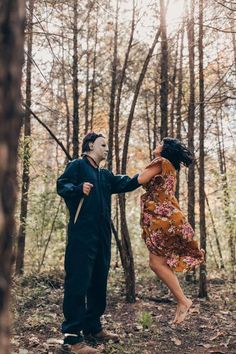 a man and woman dancing in the woods