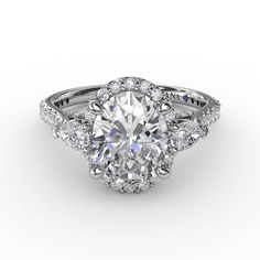 Pear-shape diamond accents elegantly wing out from the sides of this oval diamond halo engagement ring. It’s a glamorous style, with an intricately structured gallery, and diamond band, to enhance the display of light. Available in platinum, 18KT & 14KT gold. Center stone sold separately.  Style #S3280. Oval Diamond Halo Engagement Ring, Oval Halo Diamond Ring, Pave Band Engagement Ring, Pear Engagement Ring Halo, Halo Engagement Ring Sets, Pave Diamond Band, Future Engagement Rings, Diamond Birthstone, Diamond Halo Engagement Ring