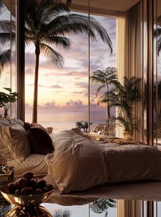 a bedroom with a large window overlooking the ocean and palm trees in front of it