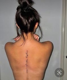 the back of a woman's upper body with writing on her left shoulder and right arm