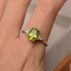 This halo ring features a 7*9mm oval cut real peridot and sterling silver finished with rhodium. Customization is available. It is made by hand, and it will take about 7 days to finish the ring after your payment is completed. Main stone: natural peridot (August birthstone) Peridot weight: Approx 2.25 ct Metal type: sterling silver / 14k gold Accent stone: cz Customization is available, I also can make it with 14k solid gold (white or yellow or rose) and diamond accent stone, just feel free to c Peridot Ring Engagement, Peridot Engagement Rings, August Birthstone Ring, Green Gemstone Ring, Future Engagement Rings, Art Deco Wedding Rings, Wedding Anniversary Rings, Peridot Stone, August Birthstone