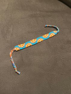 a blue and orange lanyard with an elephant on it's side sitting on a black surface