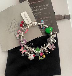 a bracelet with charms on it sitting next to a card