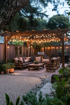 Backyard patio with wooden pergola and string lights, featuring outdoor furniture and a gravel pathway. Diy Outdoor Dining Area, Backyard Small Ideas, Backyard Oasis Ideas Inspiration, Country Style Backyard, Country Backyard Ideas, Backyard Hangout Ideas, Desert Backyard Ideas, Oasis Backyard Ideas, Small Backyard Oasis