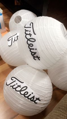 three large white paper lanterns sitting on top of a wooden floor