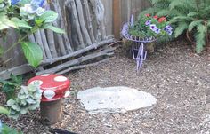 a red fire hydrant sitting in the middle of a garden next to a wooden fence