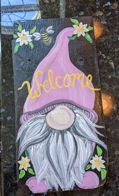 a painted welcome sign with a gnome's head