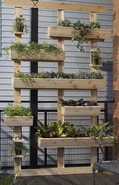 an outdoor planter made out of wooden pallets with plants growing in them and hanging on the side of a building