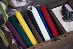 an assortment of candles in a wooden box