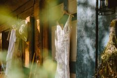 wedding gowns are hanging on the clothesline in front of an open door to a building