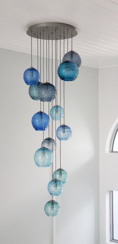 a chandelier with blue glass balls hanging from it's sides in a room