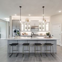 a kitchen with an island and three stools