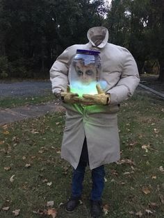 a man in a lab coat is holding a jar with a glowing light inside it