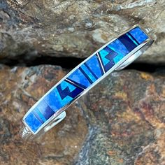 This Beautiful Sterling Silver Bracelet as part of the Blue Sky Collection, features Royal Lapis, Denim Lapis and Cultured Opal in a Fancy Inlaid Pattern. Choose Bracelet Wrist Size based on Total Circumference of Wrist. Dimensions: 3/8" at widest They are designed by David Rosales, one of the finest contemporary Southwest Artists in the world. He is the founder and co-owner of Supersmiths, Inc. of Gallup, NM. Each Handcrafted Bracelet is custom made and carries a lifetime guarantee. Buffalo Jewelry, Contemporary Southwest, Beautiful Blue Sky, Spiny Oyster Jewelry, Lapis Jewelry, Bracelet Wrist, Sky Collection, Black Arrow, Silver Belt Buckle