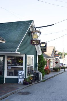 a green building with a sign that says coffee house on the front and side of it