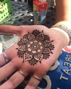 a woman's hand with a henna tattoo on it